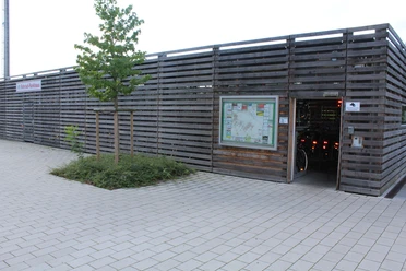 Fahrradstation Kirchweyhe Fahrradverleihstation mit Holzfassade, Informationsschild, Zugang zur Aufbewahrung von Fahrrädern.