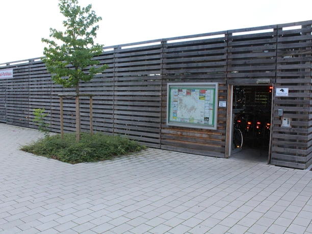 Fahrradstation Kirchweyhe Fahrradverleihstation mit Holzfassade, Informationsschild, Zugang zur Aufbewahrung von Fahrrädern.