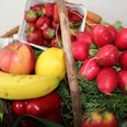 Obst und Gemüse Frisches Obst und Gemüse arrangiert in einem Korb, darunter Banane, Erdbeeren, Radieschen.