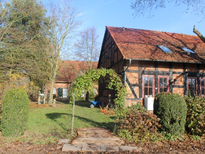 Ein traditionelles Fachwerkhaus mit roten Ziegeln und gepflegtem Garten unter blauem Himmel.A traditional half-timbered house with red bricks and a well-tended garden under a blue sky.Et traditionelt bindingsværkshus med røde mursten og en velplejet have under en blå himmel.Een traditioneel vakwerkhuis met rode bakstenen en een goed onderhouden tuin onder een blauwe hemel.