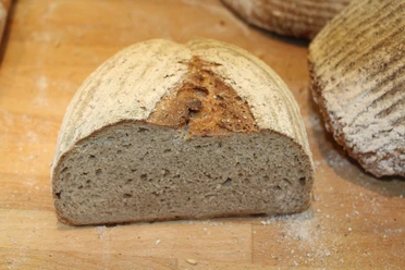 Gehalveerd, knapperig brood op een houten plank bestoven met fijn meel.