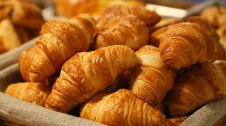 bread-1284438_1920.jpg Ein Korb mit knusprigen Croissants aus goldenem Blätterteig, frisch gebacken und appetitlich angerichtet.