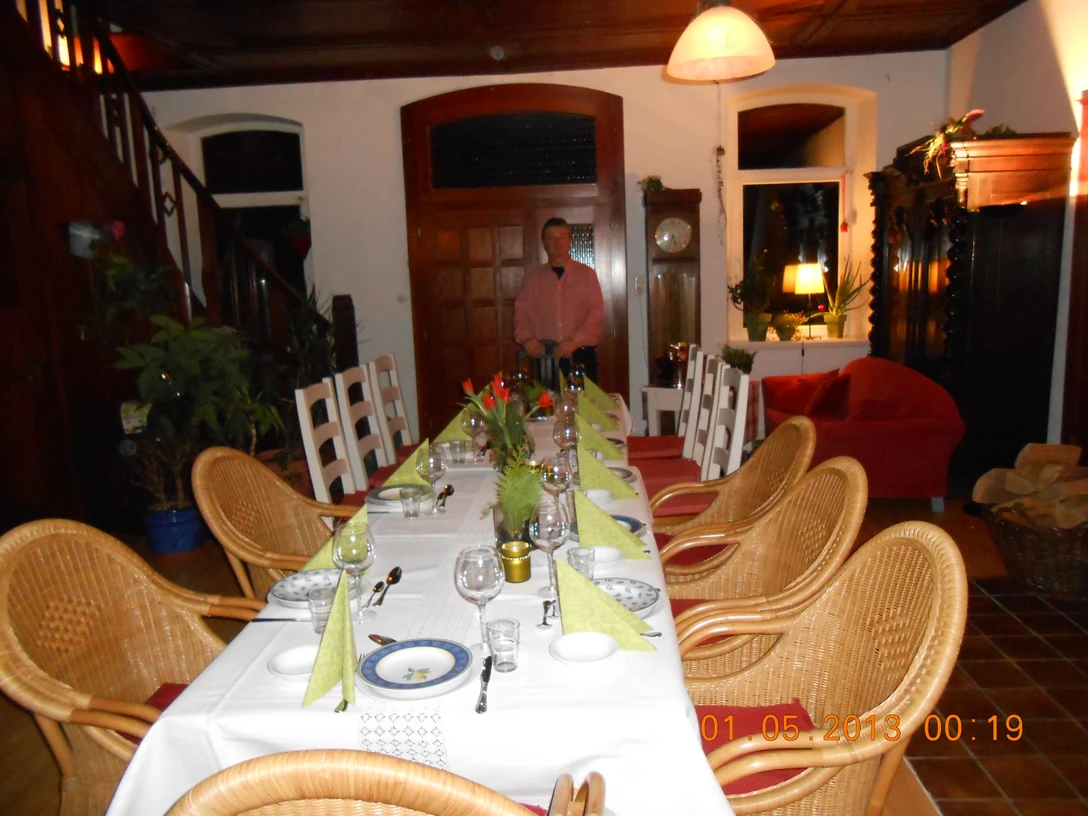 Amayra Immobilien GmbH Ein festlich gedeckter Tisch in einem hell erleuchteten Raum mit rustikalen Möbeln und Pflanzen.