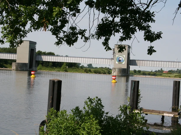 Wehr Dörverden Wasserwehr Dörverden mit Brückenbauwerken, gelben Bojen im Fluss, umgeben von Bäumen und Grün.