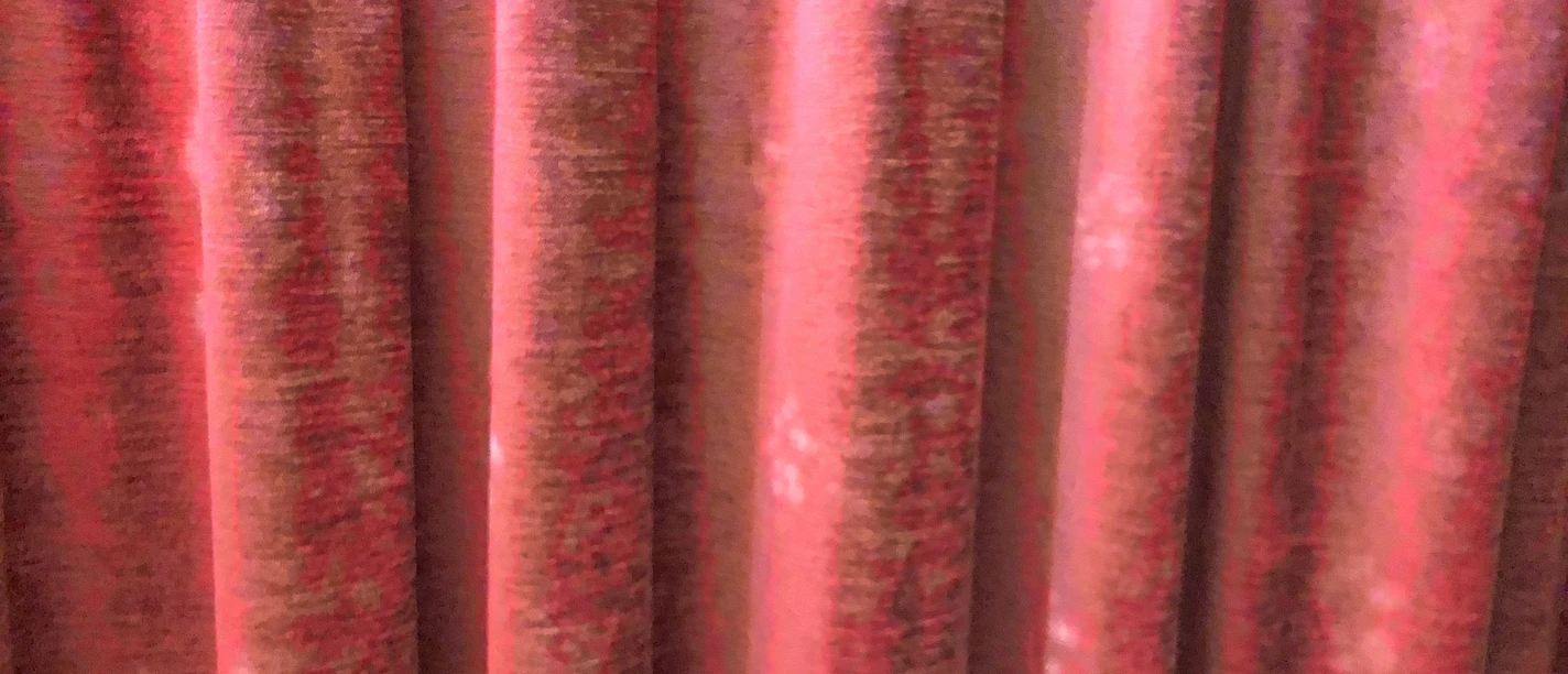 Roter Theatervorhang aus Samt, in Falten gelegt, vermittelt Eleganz und Vorfreude auf die Aufführung.