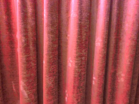 Roter Theatervorhang aus Samt, in Falten gelegt, vermittelt Eleganz und Vorfreude auf die Aufführung.