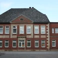 Bollmann-Haus Historisches Backsteingebäude mit symmetrischer Fassade, zehn Fenstern und einem Eingang auf Kiesweg.