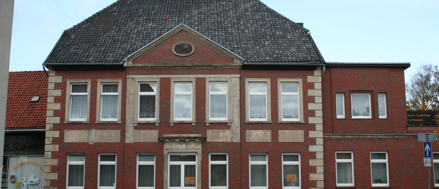Bollmann-Haus Historisches Backsteingebäude mit symmetrischer Fassade, zehn Fenstern und einem Eingang auf Kiesweg.