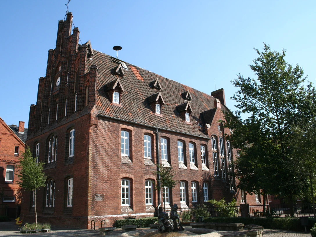 Grundschule Hoya Historisches Backsteingebäude mit spitzem Giebel, hohen Fenstern und verzierten Dachgauben in Hoya.