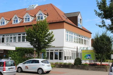 Rathaus Bruchhausen-Vilsen Rathaus Bruchhausen-Vilsen: Modernes Bauwerk mit spitzem Giebeldach, umgeben von grünen Bäumen.