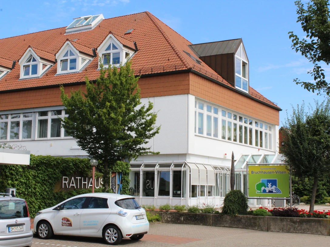 Rathaus Bruchhausen-Vilsen Rathaus Bruchhausen-Vilsen: Modernes Bauwerk mit spitzem Giebeldach, umgeben von grünen Bäumen.