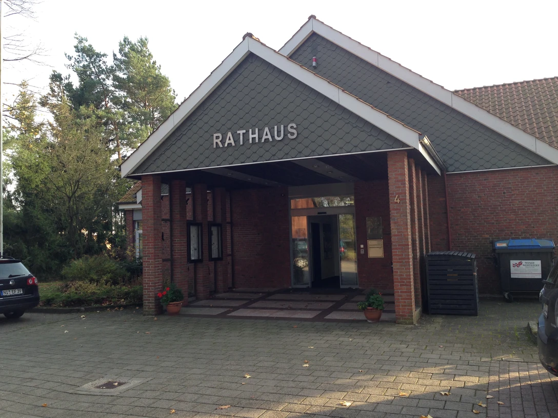 Historisches Backsteingebäude mit schrägem Dach und Arkaden, bekannt als Rathaus Heemsen.