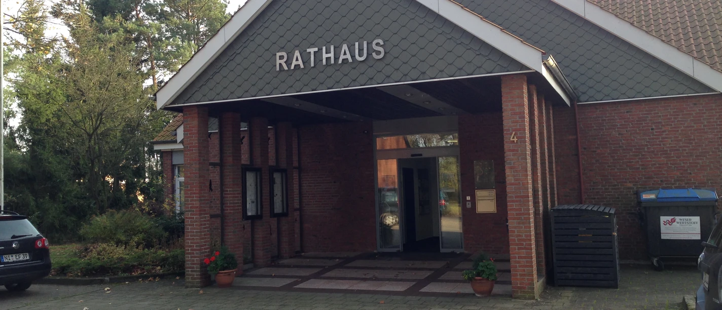 Historisches Backsteingebäude mit schrägem Dach und Arkaden, bekannt als Rathaus Heemsen.