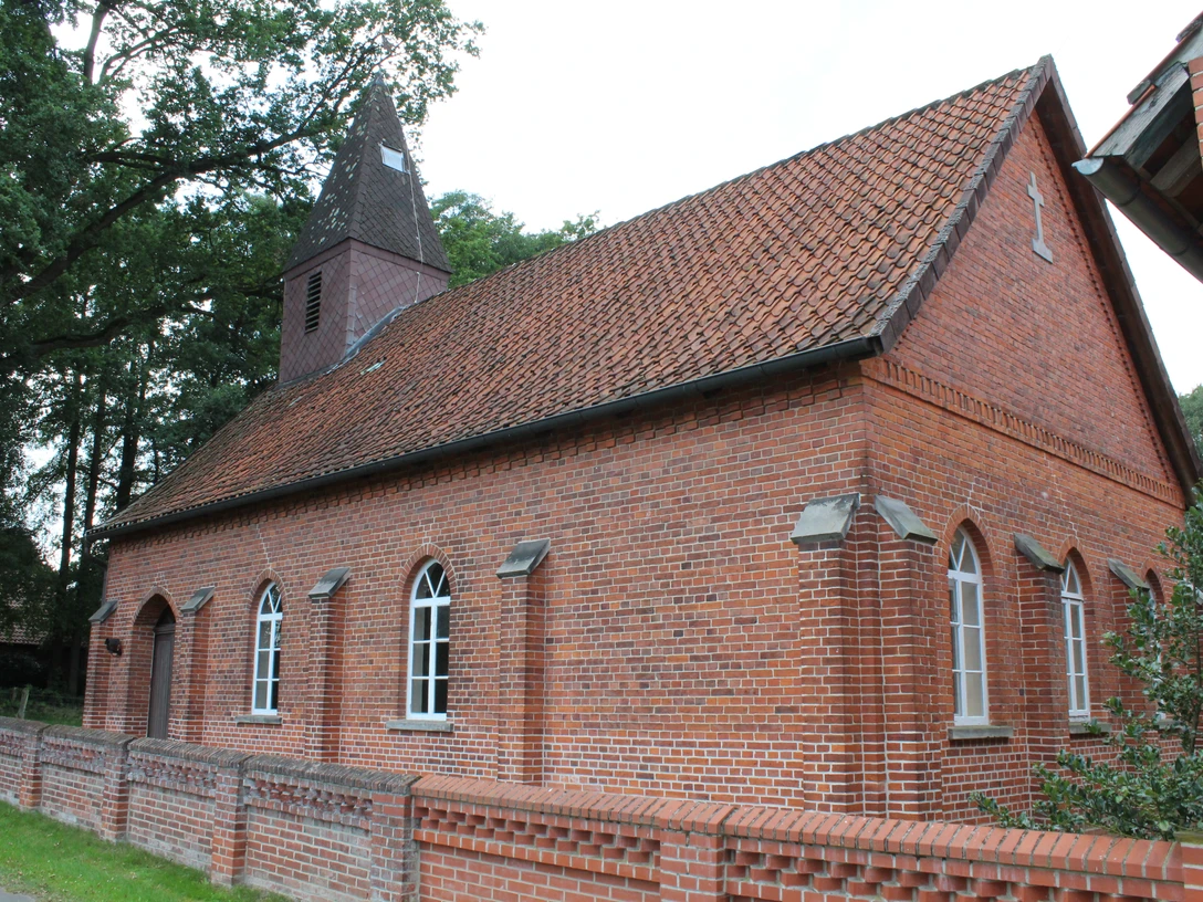 Kapelle Wendenborstel Rote Backsteinkapelle mit spitzem Turm, umgeben von Bäumen, Teil des Dorfes Wendenborstel.