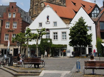 Der Marktplatz in Rheine Historische Gebäude mit Fachwerk und roten Dächern umgeben den lebhaften Rheiner Marktplatz.