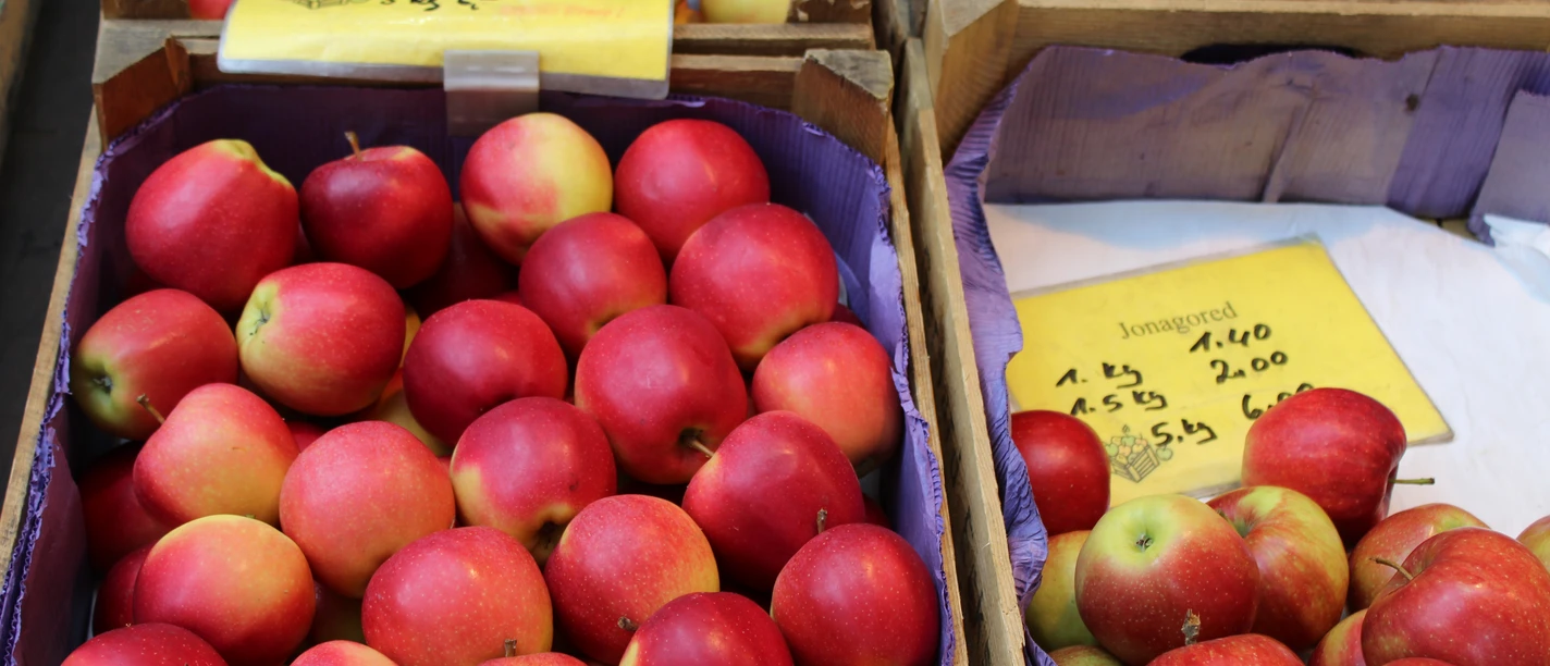 Äpfel Reife, rote und gelbe Äpfel in Holzkisten auf einem Marktstand mit Preisetiketten darauf.