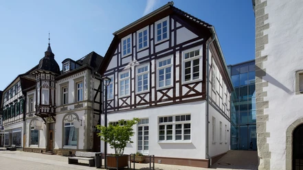 Verwaltungsnebenstelle der Stadt Brakel Zweistöckiges Fachwerkhaus mit weißen Fassaden und dunkelbraunen Holzbalken, seitlich Straße.
