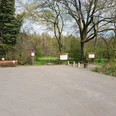 Wanderparkplatz "Schwarzer Brink" Parkplatz mit Bäumen, Informationstafeln und Sitzbänken am Waldrand, ohne Park- und Halteverbotsschild.