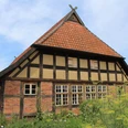 Fachwerkhaus in Dörverden mit roten Ziegeln, Sprossenfenstern und einem steilen Satteldach.
