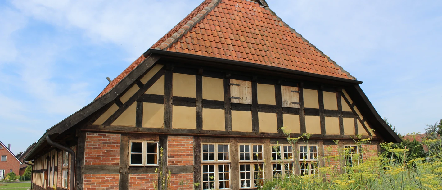 Fachwerkhaus in Dörverden mit roten Ziegeln, Sprossenfenstern und einem steilen Satteldach.