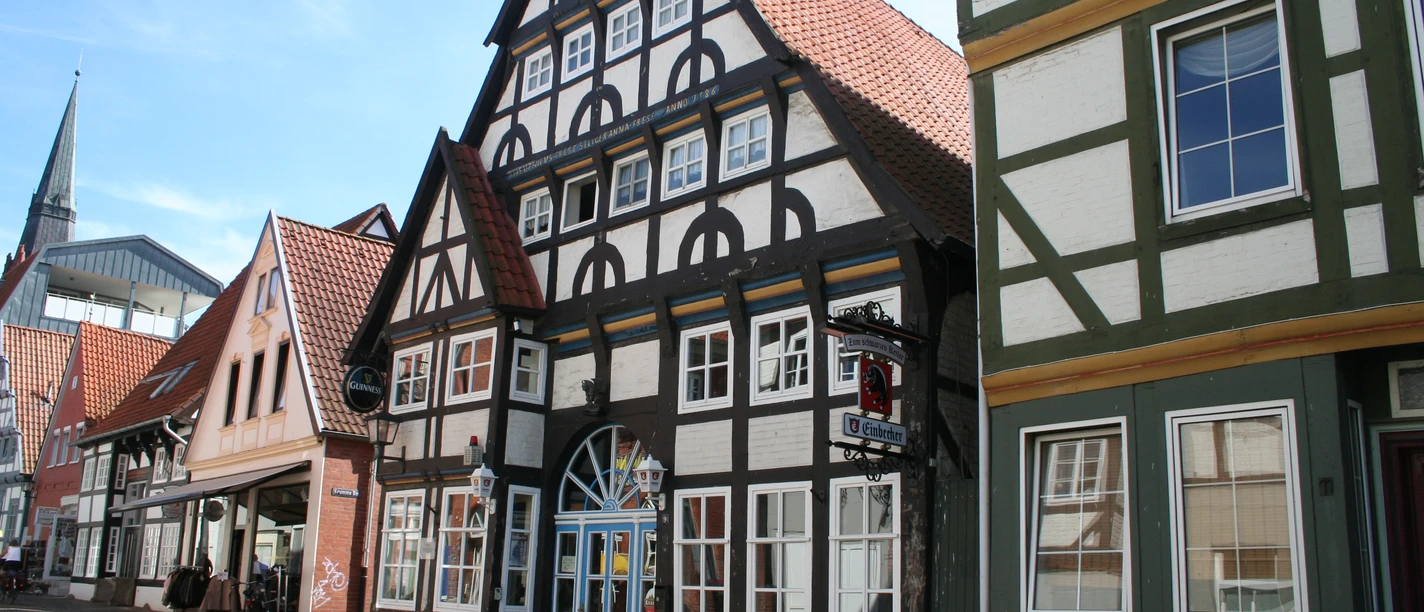 Bürgerhaus Bindingsværksbygninger med røde tegltage, typisk nordtysk stil, gadebillede i solskin.