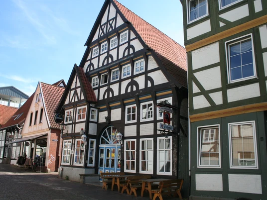 Bürgerhaus Fachwerkgebäude mit roten Ziegeldächern, typisch norddeutscher Stil, Straßenszene im Sonnenschein.Half-timbered building with red tiled roofs, typical North German style, street scene in the sunshine.Bindingsværksbygninger med røde tegltage, typisk nordtysk stil, gadebillede i solskin.Vakwerkhuizen met rode pannendaken, typische Noord-Duitse stijl, straatbeeld in de zon.