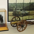 Eine alte Kanone und moderne Panzerartillerie in einer militärhistorischen Ausstellung.