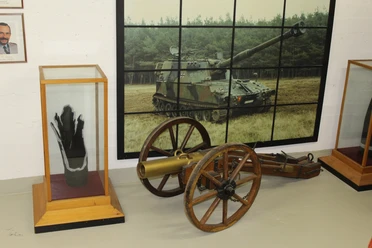 Militärhistorische Ausstellung Eine alte Kanone und moderne Panzerartillerie in einer militärhistorischen Ausstellung.