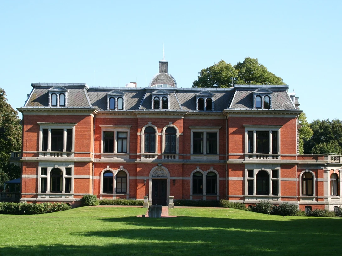 Historisch wirkendes Backsteinschloss Etelsen mit zinnenverziertem Dach, umgeben von Grünflächen.Historic-looking brick castle Etelsen with crenellated roof, surrounded by green spaces.Historisk udseende murstensborg Etelsen med kreneleret tag, omgivet af grønne områder.Historisch uitziend bakstenen kasteel Etelsen met gekanteld dak, omgeven door groene ruimten.