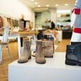 PREGO Das Bild zeigt moderne Schuhe und Stiefel in einer stilvollen Boutique auf hölzernem Boden präsentiert.The picture shows modern shoes and boots presented in a stylish boutique on a wooden floor.