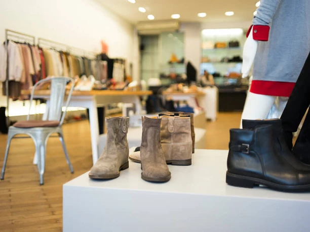 PREGO The picture shows modern shoes and boots presented in a stylish boutique on a wooden floor.