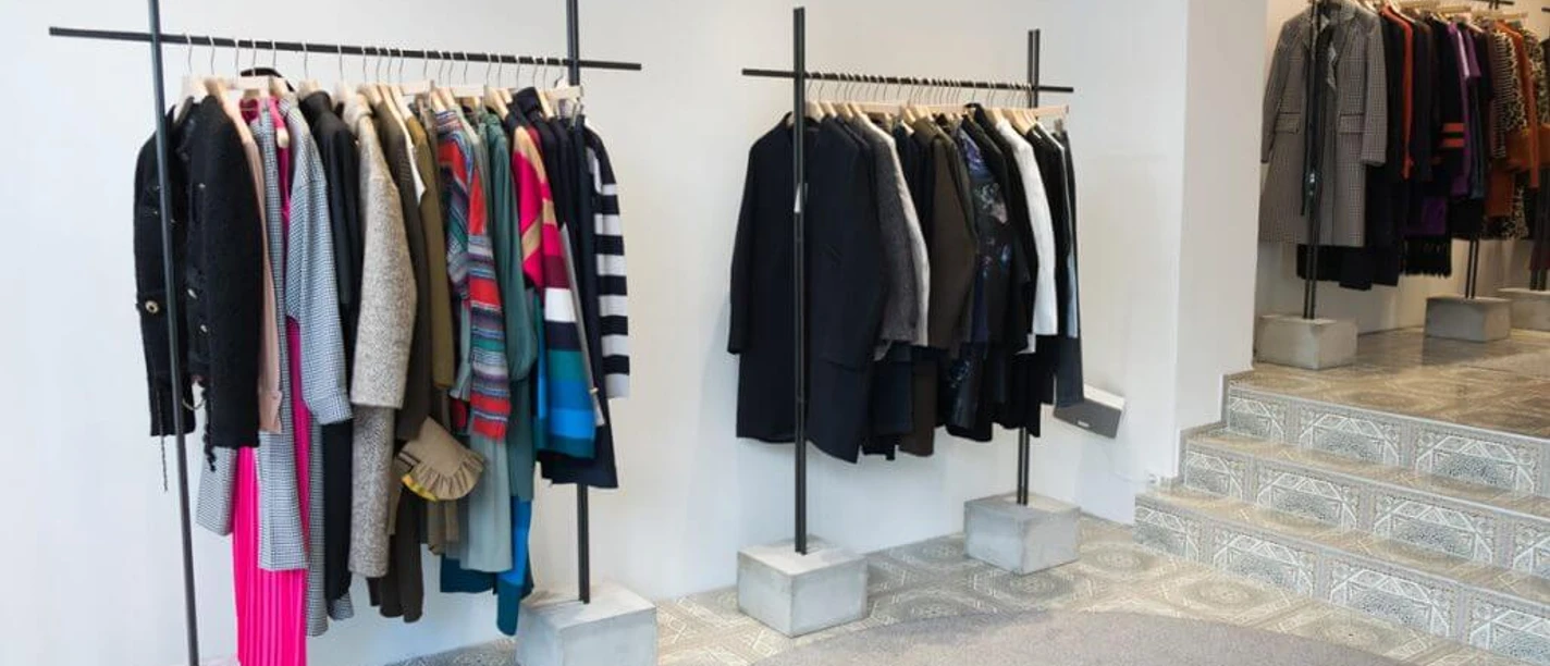 MATA Cologne Interior view of a fashion store with colorful and neutral garments on clothes rails.