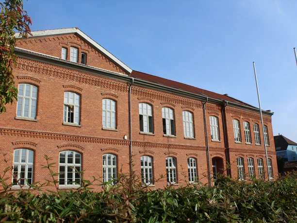 Historisches Backsteingebäude der Polizeiakademie Niedersachsen mit blauen Himmel im Hintergrund.