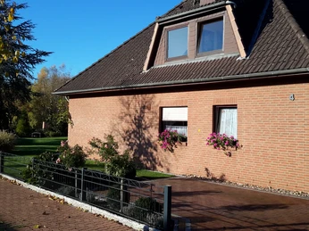 Familie Jäger Ein rotes Backsteinhaus mit Spitzdach, umgeben von bunten Blumen und einem gepflegten Rasen.A red brick house with a pointed roof, surrounded by colorful flowers and a well-tended lawn.Et rødt murstenshus med spidst tag, omgivet af farverige blomster og en velplejet græsplæne.Een rood bakstenen huis met een puntdak, omringd door kleurrijke bloemen en een goed onderhouden gazon.