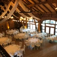 Großer, eleganter Festsaal mit Holzbalken, runden und rechteckigen Tischen und dezentem Licht.Large, elegant ballroom with wooden beams, round and rectangular tables and subtle lighting.Stor, elegant balsal med træbjælker, runde og rektangulære borde og afdæmpet belysning.Grote, elegante balzaal met houten balken, ronde en rechthoekige tafels en subtiele verlichting.