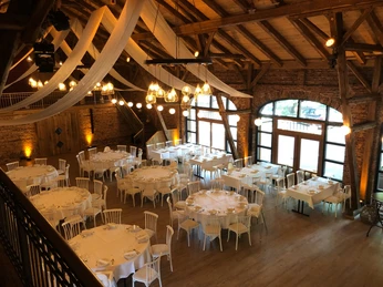 Hof Frien Festsaal Großer, eleganter Festsaal mit Holzbalken, runden und rechteckigen Tischen und dezentem Licht.Large, elegant ballroom with wooden beams, round and rectangular tables and subtle lighting.Stor, elegant balsal med træbjælker, runde og rektangulære borde og afdæmpet belysning.Grote, elegante balzaal met houten balken, ronde en rechthoekige tafels en subtiele verlichting.
