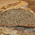 Brot Dunkles, körniges Vollkornbrot mit knuspriger Kruste in der Nahaufnahme, erkennbar Körner im Inneren.