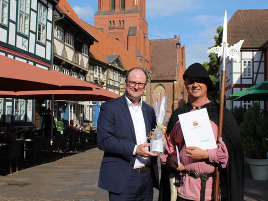 1000 Nachtwächterführung in Nienburg Zwei Männer stehen in einer historischen Gasse vor Fachwerkhäusern, einer trägt Nachtwächterkleidung.