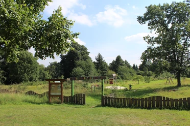 Kinderwildnis Nienburg Grüne Kinderwildnis mit Spielplatz und Bäumen, umgeben von natürlicher Vegetation in Nienburg.