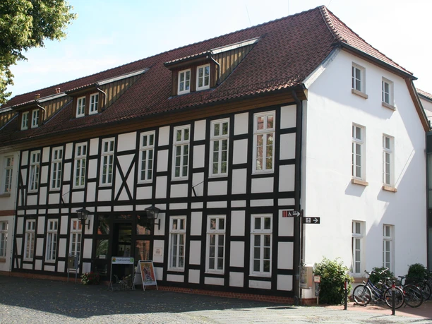 Fachwerkgebäude mit weißen Wänden und dunklen Holzelementen in Nienburg an einem sonnigen Tag.