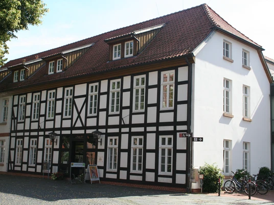 Stadtkontor Nienburg Fachwerkgebäude mit weißen Wänden und dunklen Holzelementen in Nienburg an einem sonnigen Tag.