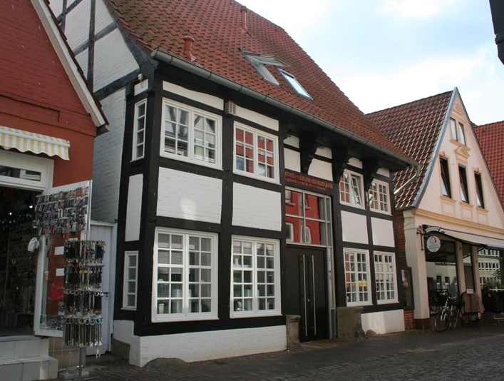 Ein traditionelles Fachwerkhaus mit weißer Fassade und schwarzem Gebälk in der Weserstraße Nienburg.