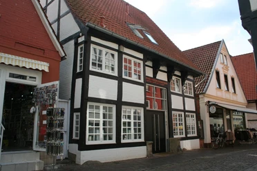 Traufenhaus Weserstraße Nienburg Ein traditionelles Fachwerkhaus mit weißer Fassade und schwarzem Gebälk in der Weserstraße Nienburg.