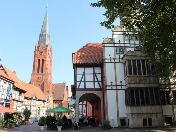 Rathaus Nienburg mit Fachwerk und modernem Turm im Hintergrund bei sonnigem Wetter im Stadtzentrum.