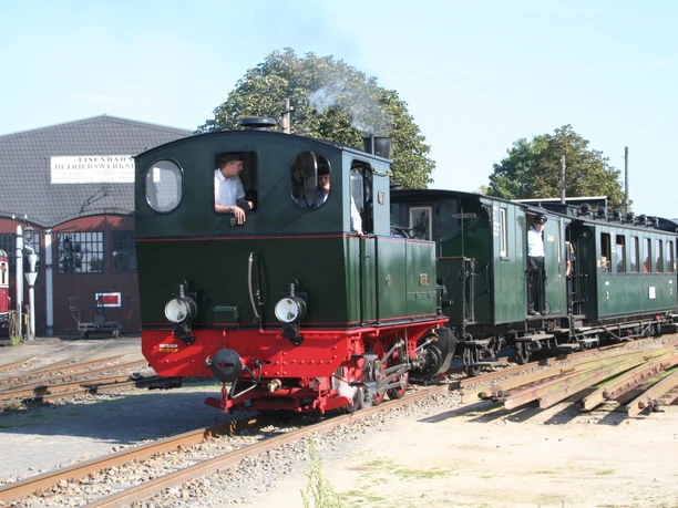 Eine historische Dampflokomotive der Museums-Eisenbahn Bruchhausen-Vilsen fährt auf einem Gleis.