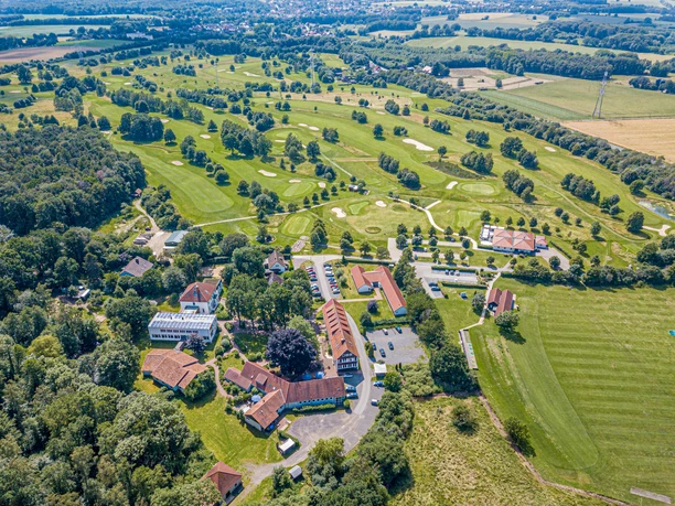 Aerial view of the Ev. Heimvolkshochschule Loccum, surrounded by green fields and woodland.