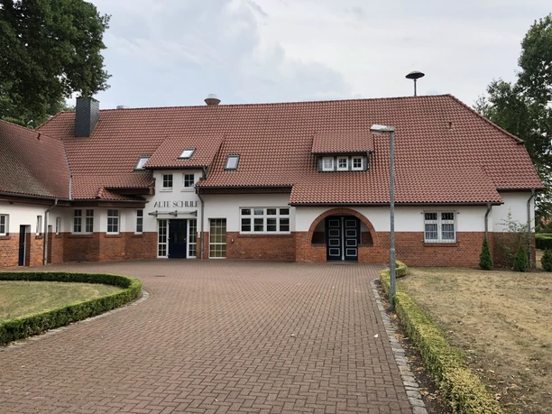 A former school building with a red-tiled roof exudes traditional charm and a majestic presence.