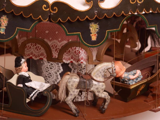 Puppenstube - Karussell Miniaturkarussell mit Puppenfiguren, Pferd und Schlitten, detailreich gestaltet im Stil vergangener Zeiten.