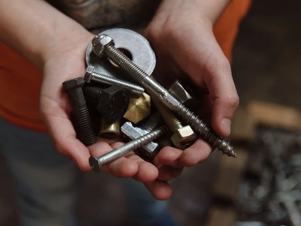 Hülden A pair of hands holds various nuts and bolts in different sizes and shapes.