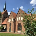 Kirche Vilsen Backsteinkirche in sommerlicher Umgebung mit Fachwerkelementen und einem markanten Kirchturm.